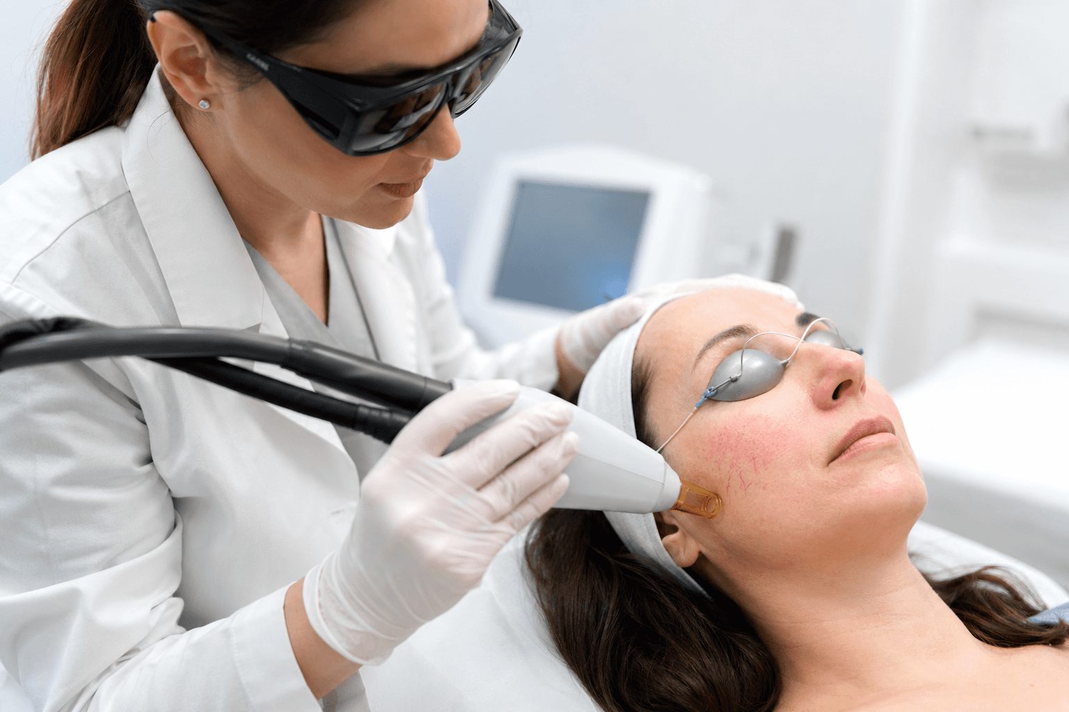 Dermatologist performing laser treatment on facial spider veins